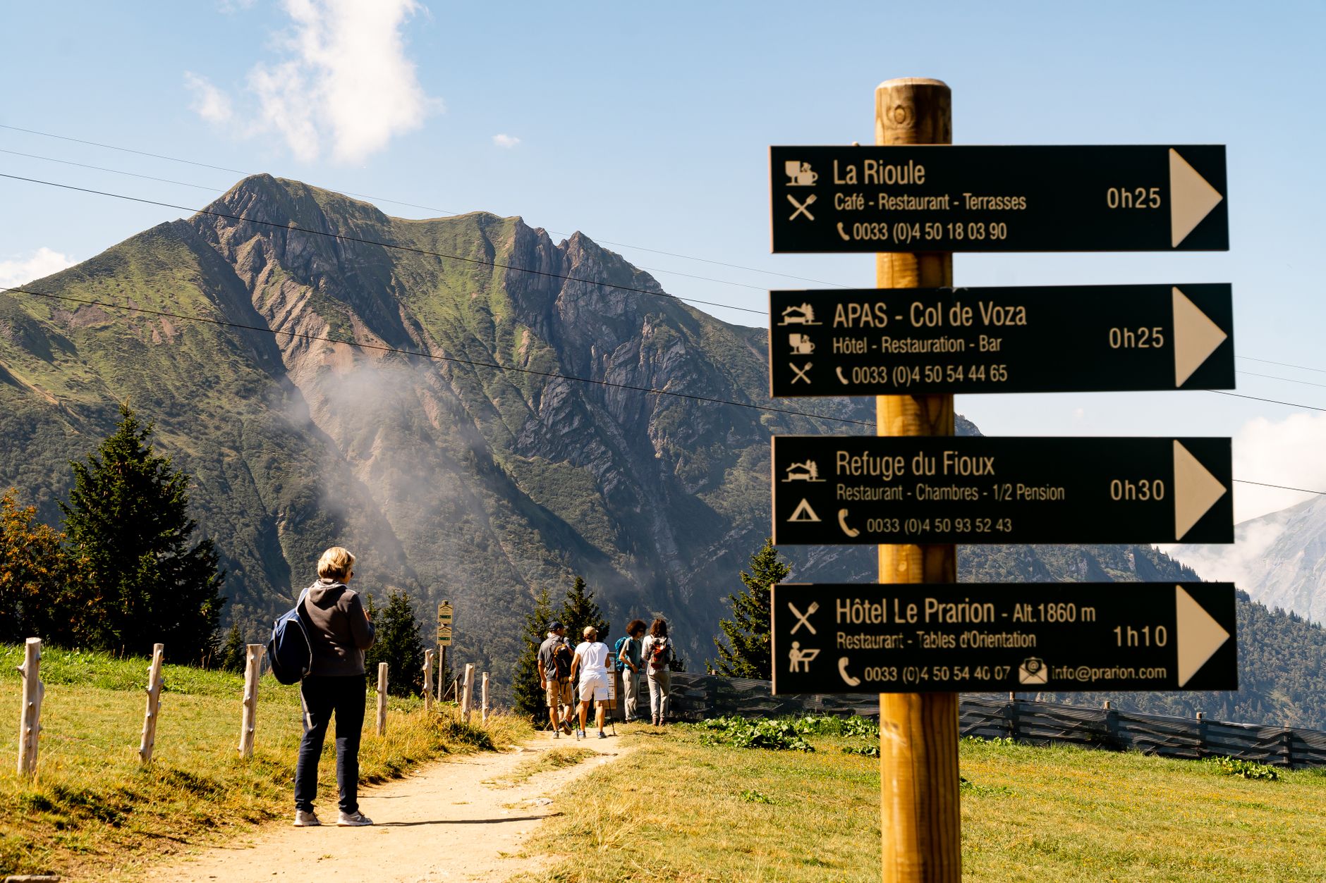 Remote alpine valley footpath with wooden directional sign