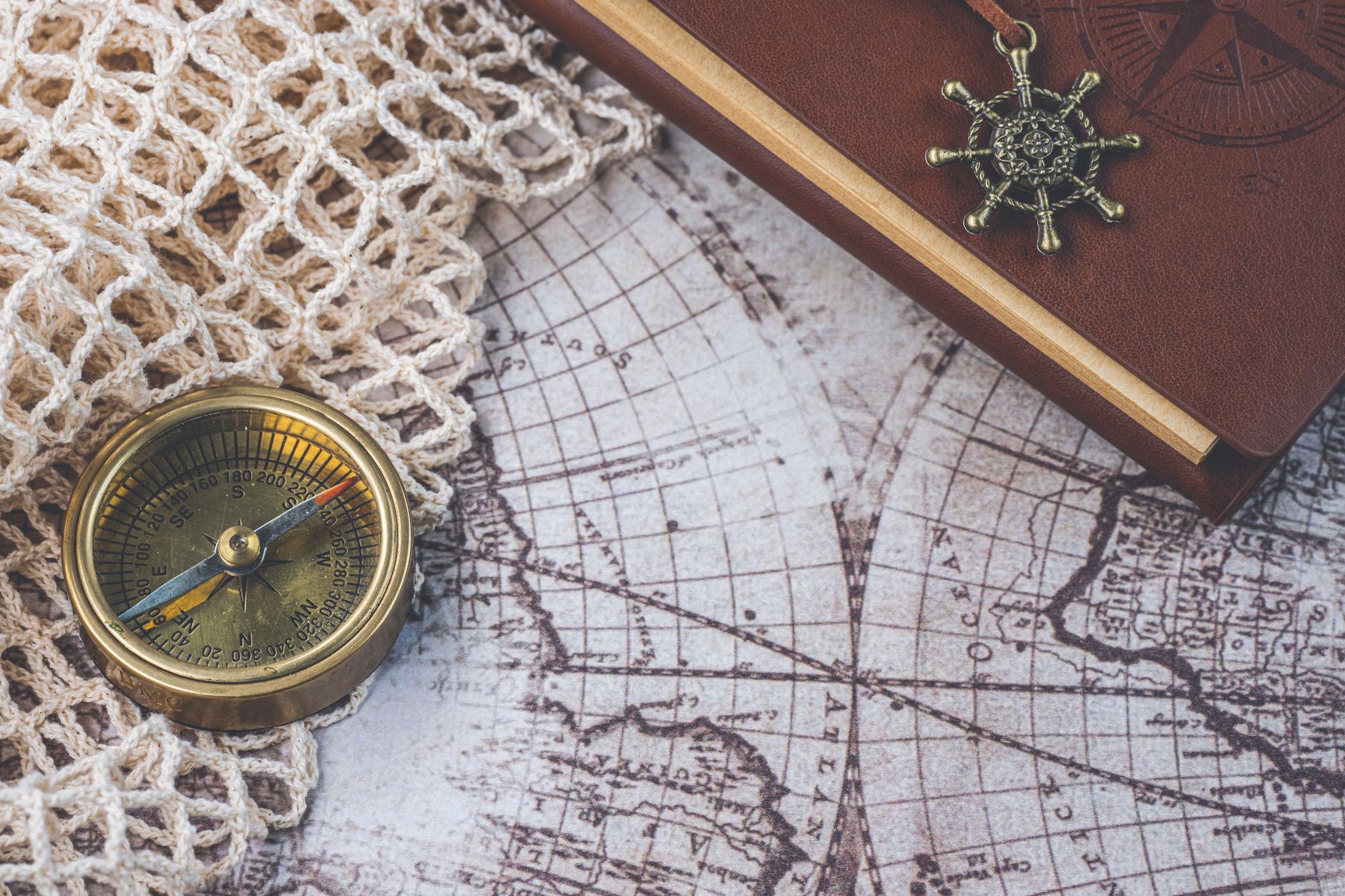 Vintage map and compass on wooden table with journal
